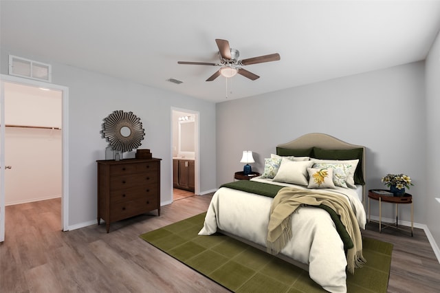 bedroom with ceiling fan, a walk in closet, wood-type flooring, a closet, and ensuite bathroom