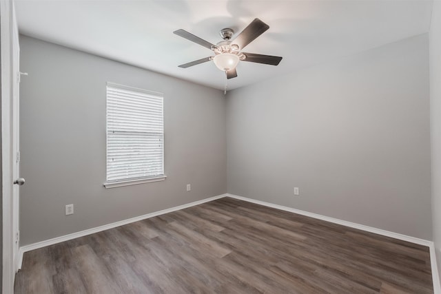 empty room with ceiling fan, baseboards, and dark wood finished floors