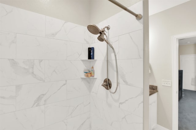 bathroom with vanity and tiled shower