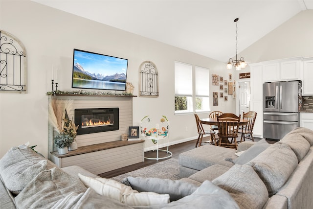 living room with a notable chandelier, dark hardwood / wood-style floors, and lofted ceiling