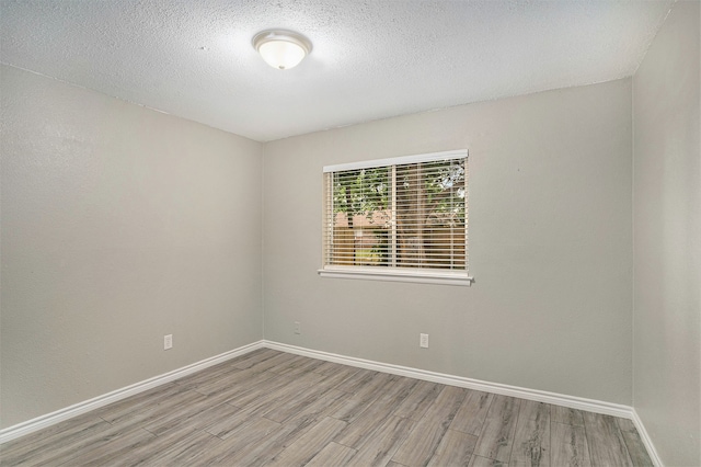 spare room with hardwood / wood-style flooring and a textured ceiling