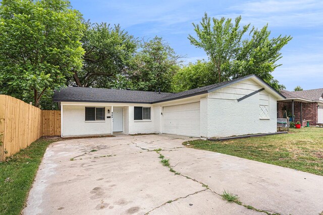 ranch-style home with a front lawn and a garage