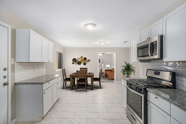 kitchen featuring backsplash, stainless steel appliances, and white cabinetry