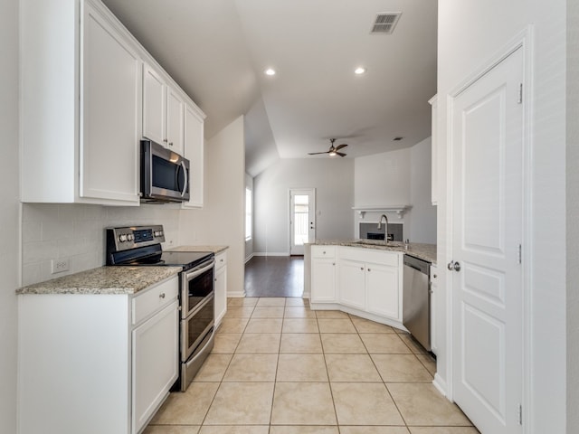 kitchen featuring ceiling fan, light wood-type flooring, appliances with stainless steel finishes, sink, and kitchen peninsula