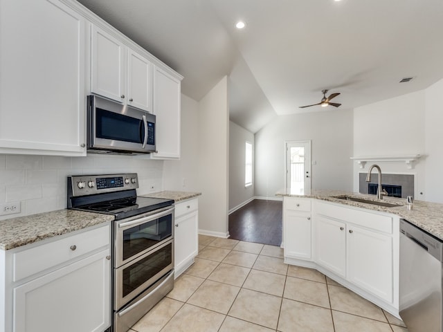 kitchen with stainless steel appliances, sink, light wood-type flooring, lofted ceiling, and ceiling fan