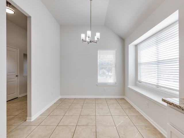 unfurnished dining area featuring a notable chandelier, vaulted ceiling, and light tile patterned floors