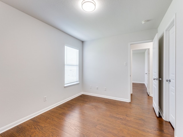 spare room with dark wood-type flooring