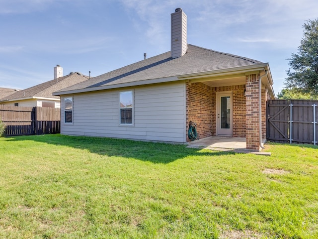 rear view of property featuring a patio and a yard