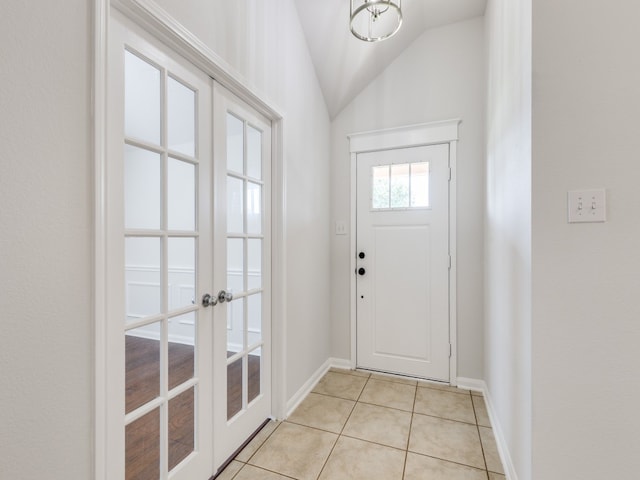 entryway with vaulted ceiling, french doors, and light tile patterned flooring