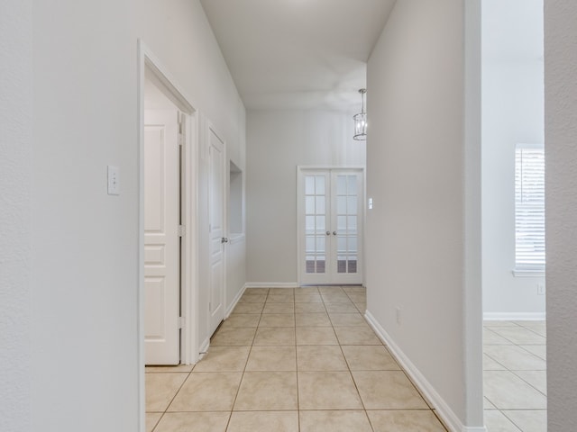 hall featuring light tile patterned floors and french doors