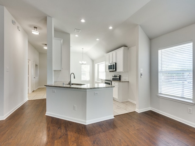 kitchen with light hardwood / wood-style flooring, tasteful backsplash, appliances with stainless steel finishes, sink, and lofted ceiling