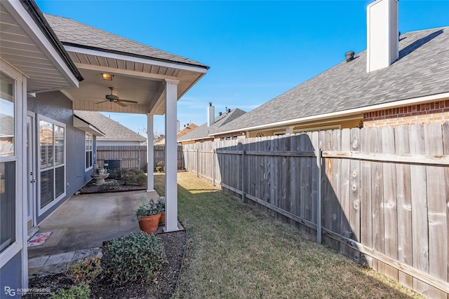 view of yard featuring cooling unit, ceiling fan, and a patio