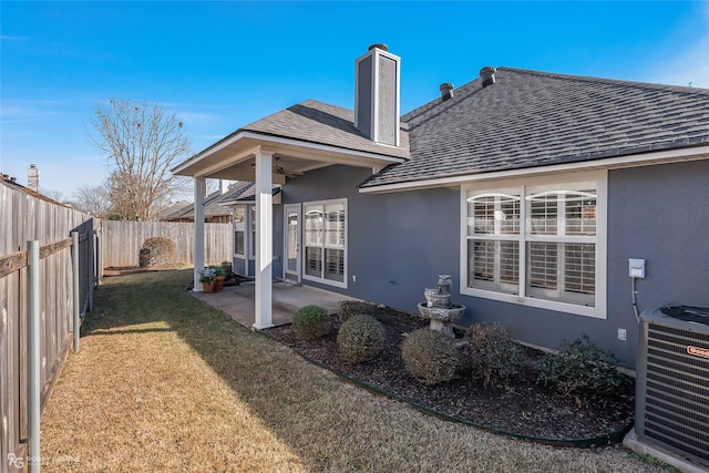 rear view of property with central AC, a yard, and a patio