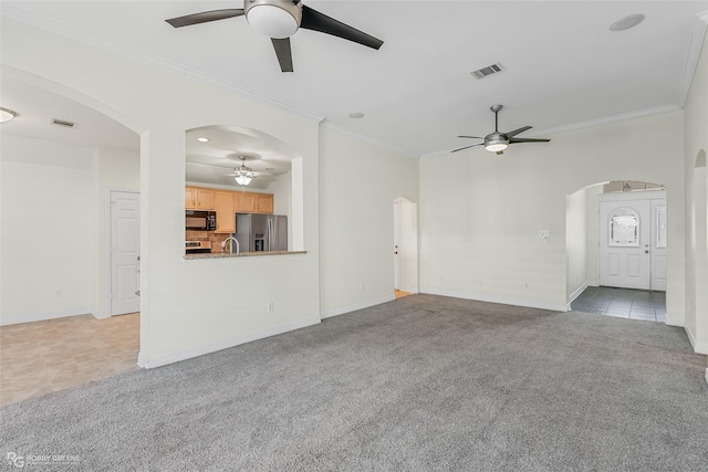 unfurnished living room featuring light carpet, sink, ornamental molding, and ceiling fan