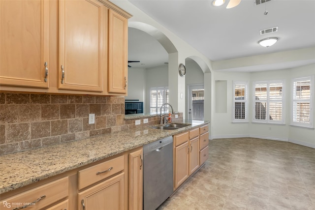 kitchen featuring light stone counters, dishwasher, sink, and light brown cabinets