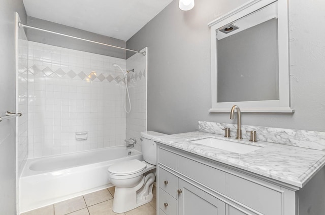 full bathroom featuring tiled shower / bath combo, tile patterned flooring, toilet, and vanity