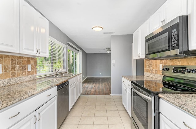 kitchen featuring ceiling fan, decorative backsplash, appliances with stainless steel finishes, and light hardwood / wood-style floors