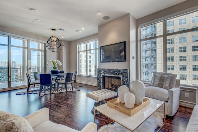 living room with a fireplace, dark hardwood / wood-style floors, and a chandelier