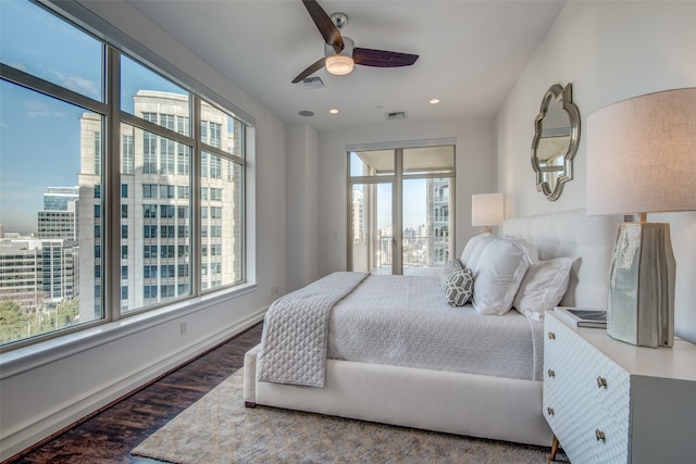 bedroom with ceiling fan, multiple windows, and dark wood-type flooring