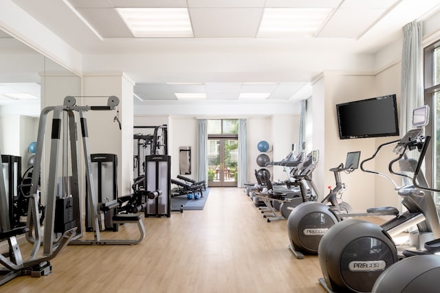 workout area with light hardwood / wood-style flooring and french doors