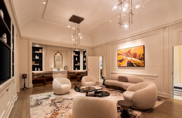 living room featuring a high ceiling, dark hardwood / wood-style floors, built in features, and a chandelier