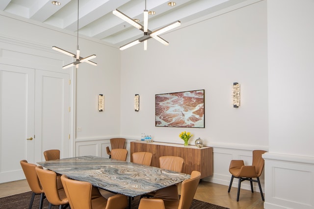 dining space with beamed ceiling, hardwood / wood-style floors, and a notable chandelier