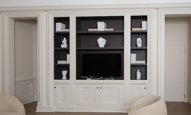 interior details featuring built in shelves and hardwood / wood-style flooring