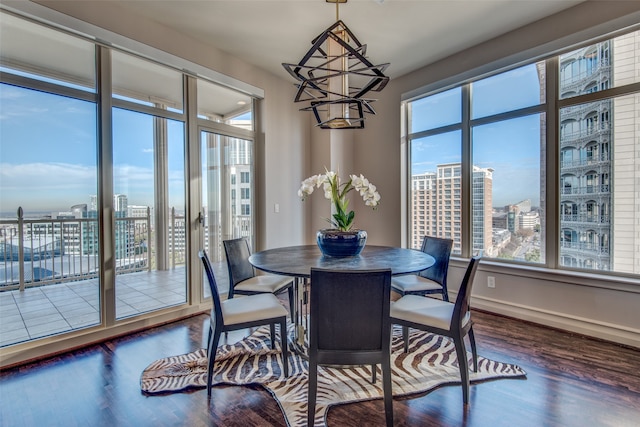 dining room with a notable chandelier, a wealth of natural light, and dark hardwood / wood-style floors