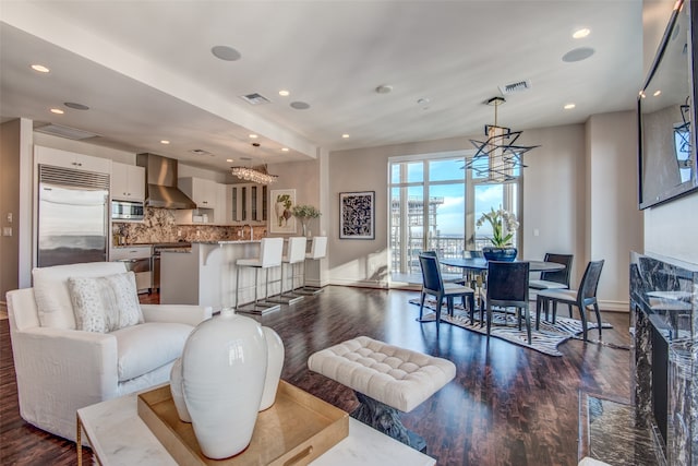 living room featuring a chandelier and dark wood-type flooring