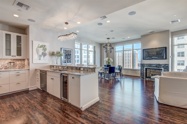 kitchen with kitchen peninsula, dark hardwood / wood-style flooring, and white cabinetry