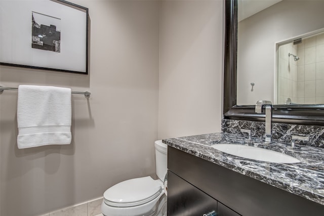 bathroom featuring a tile shower, tile patterned flooring, vanity, and toilet