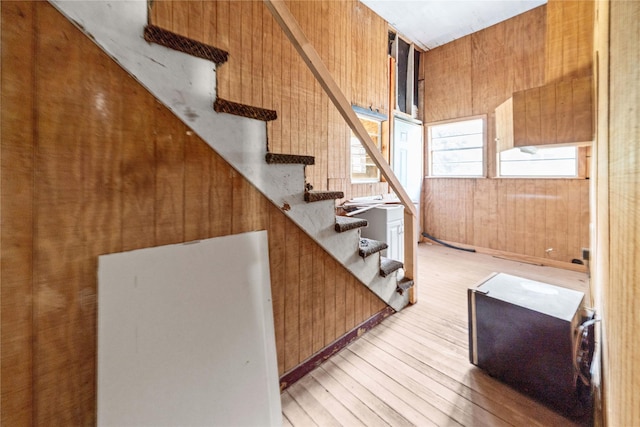 staircase featuring hardwood / wood-style flooring and wooden walls