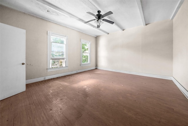 empty room featuring ceiling fan, hardwood / wood-style flooring, and beamed ceiling