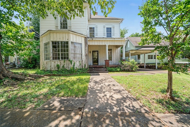 view of front of house with covered porch and a front lawn