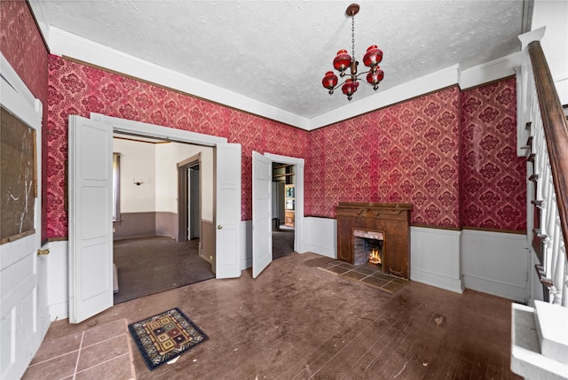 unfurnished living room featuring an inviting chandelier, wood-type flooring, and a textured ceiling