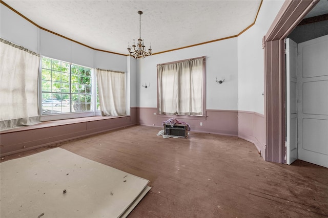 interior space with a textured ceiling, hardwood / wood-style floors, a chandelier, and ornamental molding