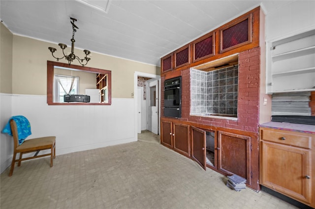 kitchen featuring oven, a notable chandelier, and pendant lighting