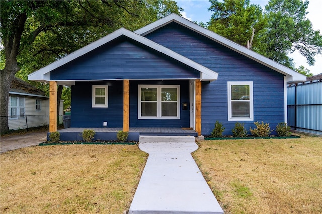 bungalow-style home featuring covered porch and a front yard