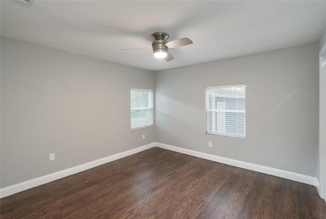 empty room with ceiling fan, baseboards, and dark wood finished floors