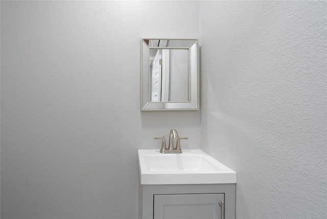 bathroom with a textured wall and vanity