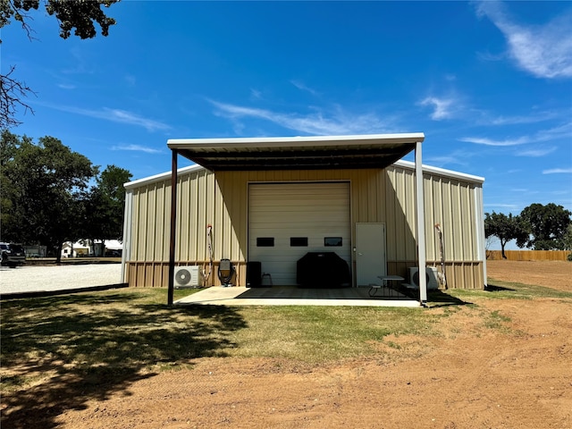 view of outdoor structure featuring a garage and a lawn