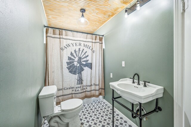 bathroom with tile patterned floors, wood ceiling, and toilet