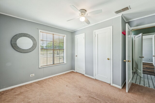 unfurnished bedroom featuring light colored carpet, ornamental molding, and ceiling fan