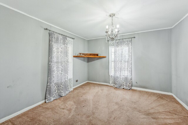 spare room with carpet, a notable chandelier, and ornamental molding