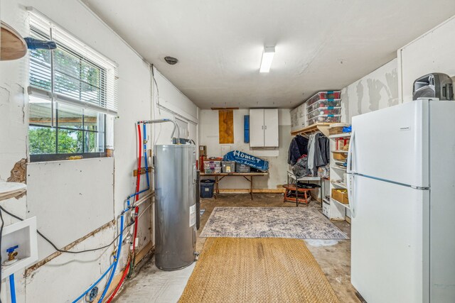 interior space featuring water heater, white fridge, and white cabinets