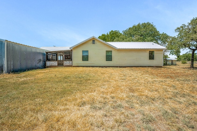 back of property featuring a sunroom and a yard