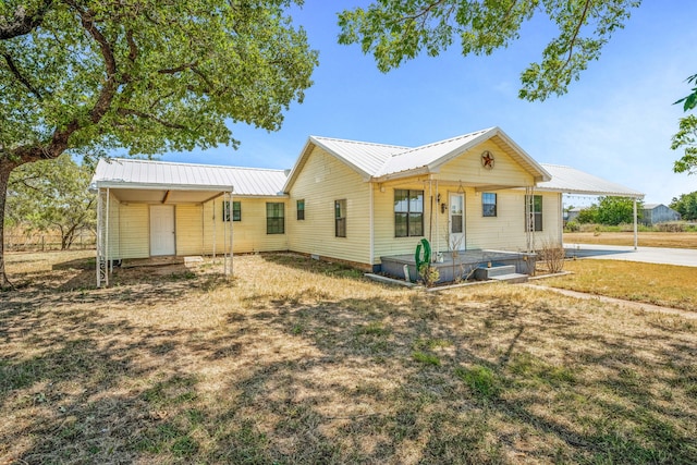 view of front of property featuring a front lawn and a carport