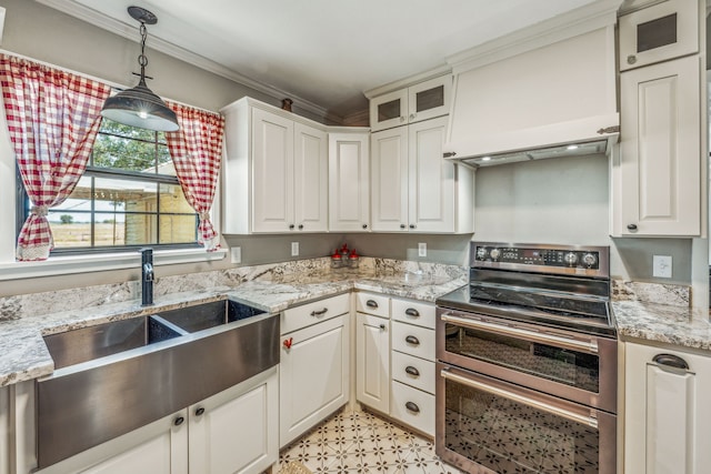 kitchen with range with two ovens, custom range hood, hanging light fixtures, glass insert cabinets, and crown molding