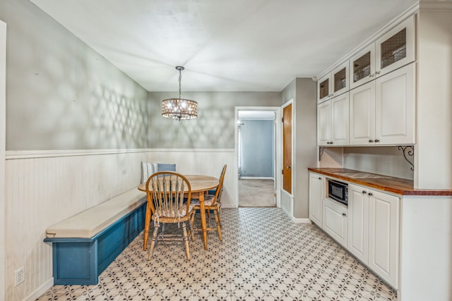 dining area featuring a notable chandelier and light tile patterned flooring