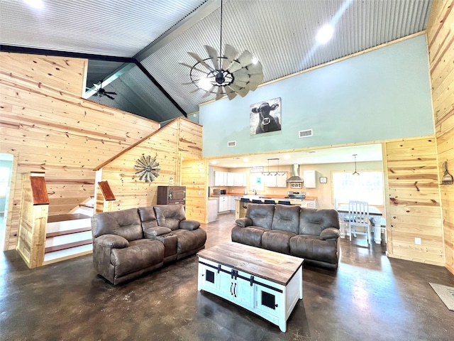 living room with wood walls, high vaulted ceiling, and ceiling fan